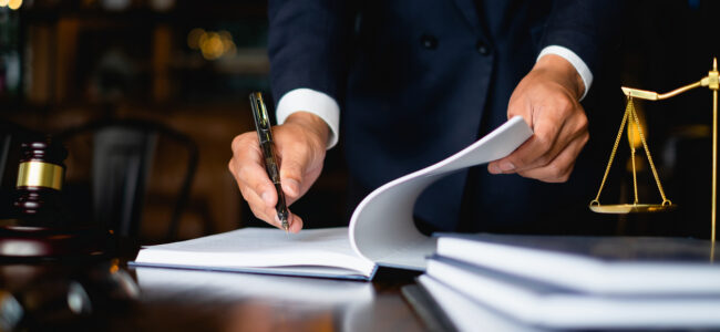 Close up lawyer businessman working or reading lawbook in office workplace for consultant lawyer concept.