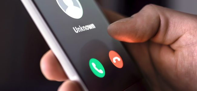 Phone call from unknown number late at night. Scam, fraud or phishing with smartphone concept. Prank caller, scammer or stranger. Man answering to incoming call.