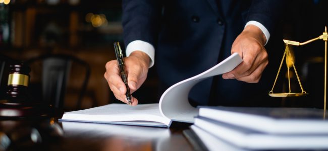 Close up lawyer businessman working or reading lawbook in office workplace for consultant lawyer concept.