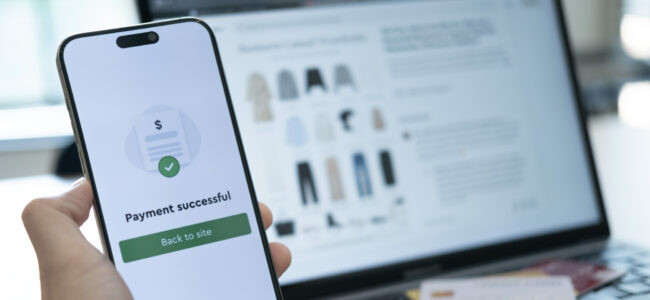 Holding a phone with payment success displayed, and a credit card placed below, highlighting the convenience of cashless payment systems used anywhere